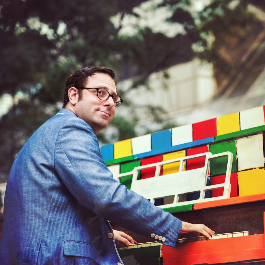 Man with hands on piano keyboard with colorful backgroun