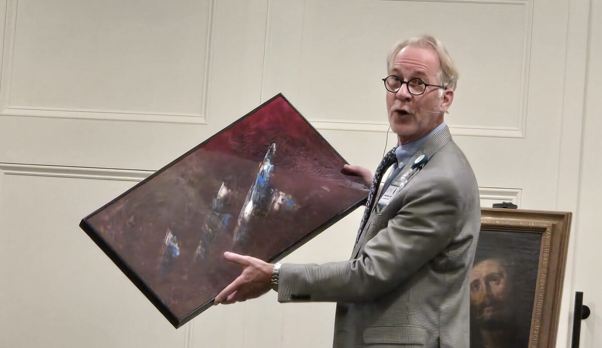 Kevin Stewart demonstrates visual difference in a partially restored painting.